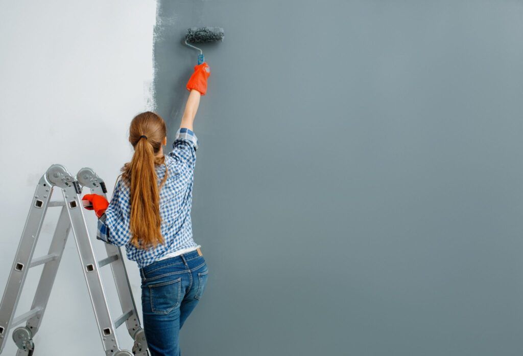 mujer pintando pared